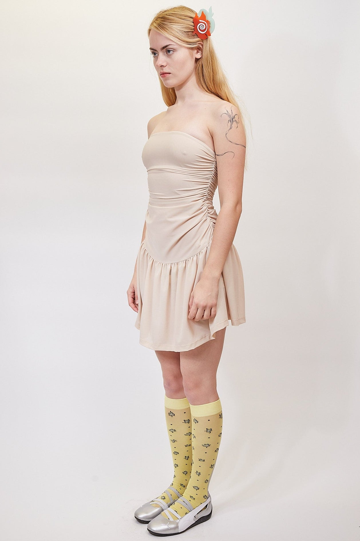 Woman wearing a beige dress and yellow socks with text on a white background