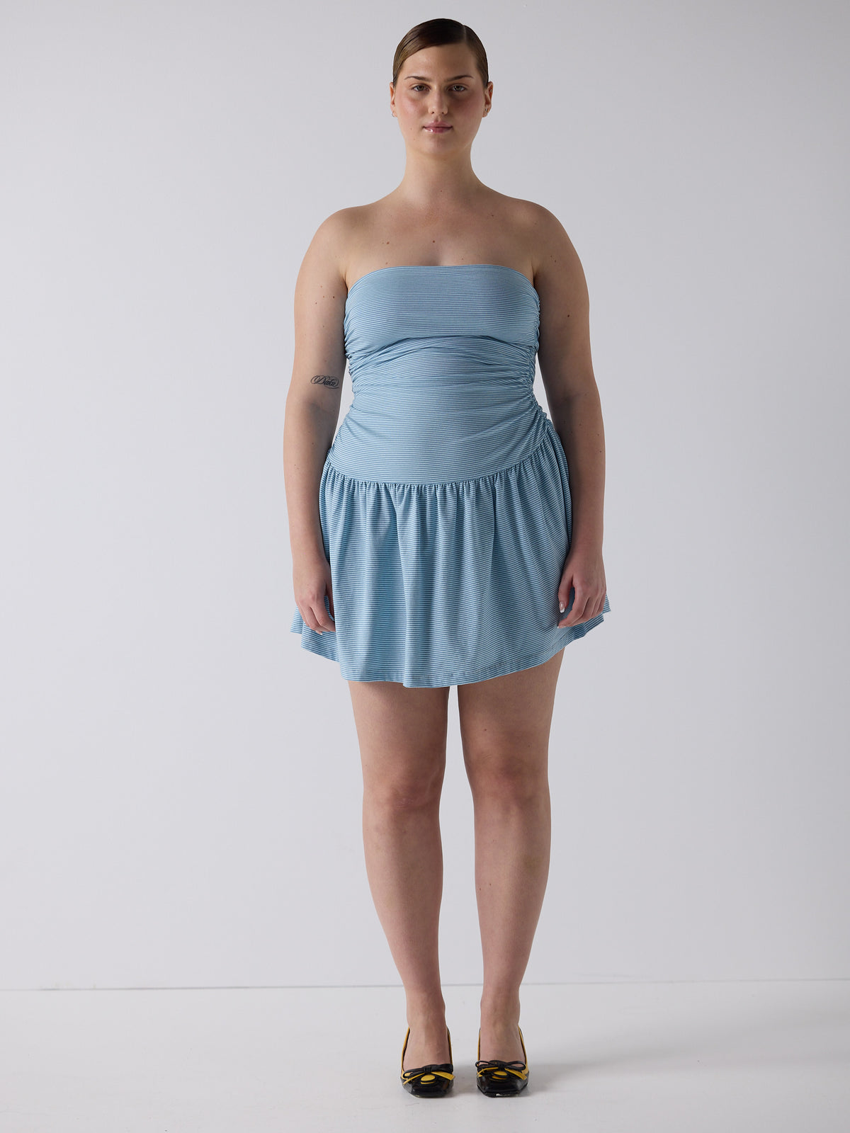 kim wears the twist dress in blue micro stripe, fit 3