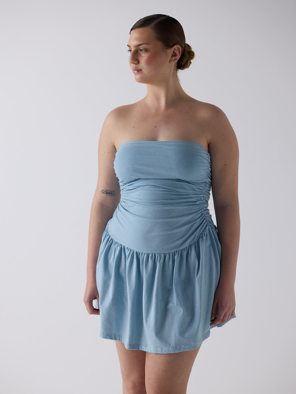 kim wears the twist dress in blue micro stripe, fit 3