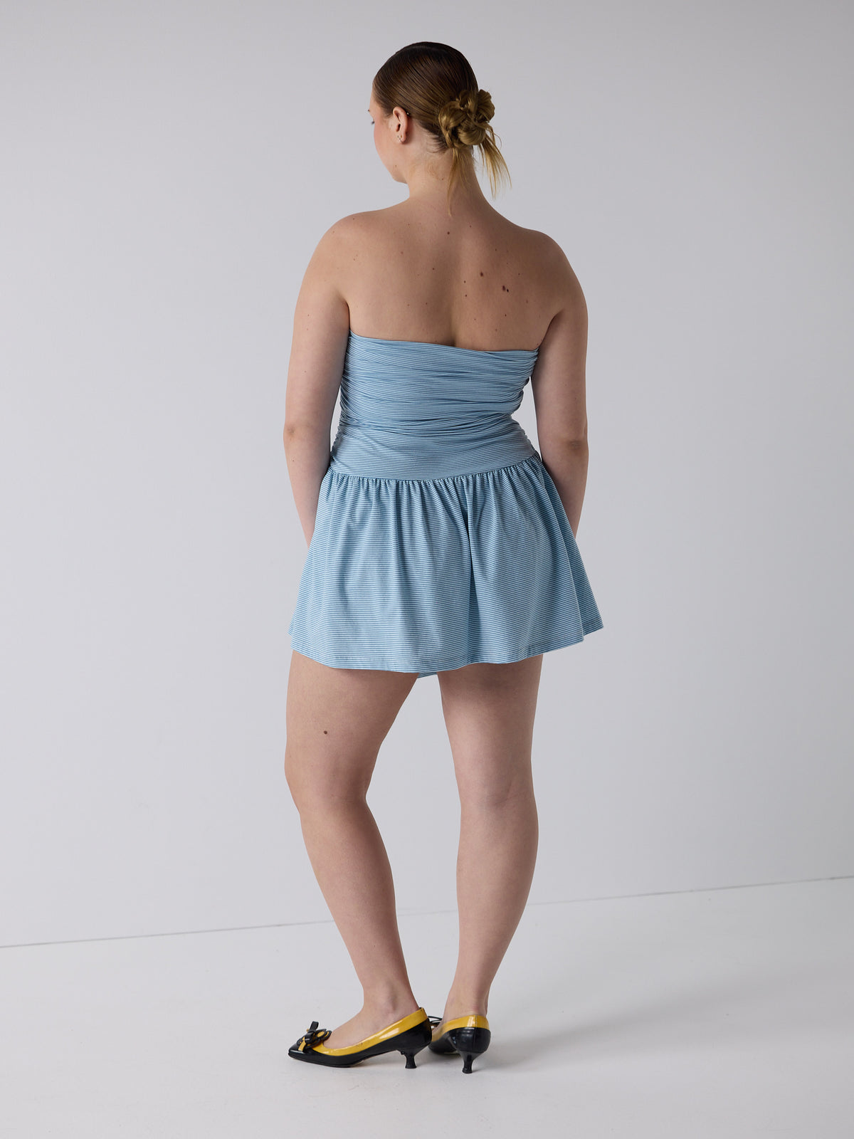 kim wears the twist dress in blue micro stripe, fit 3