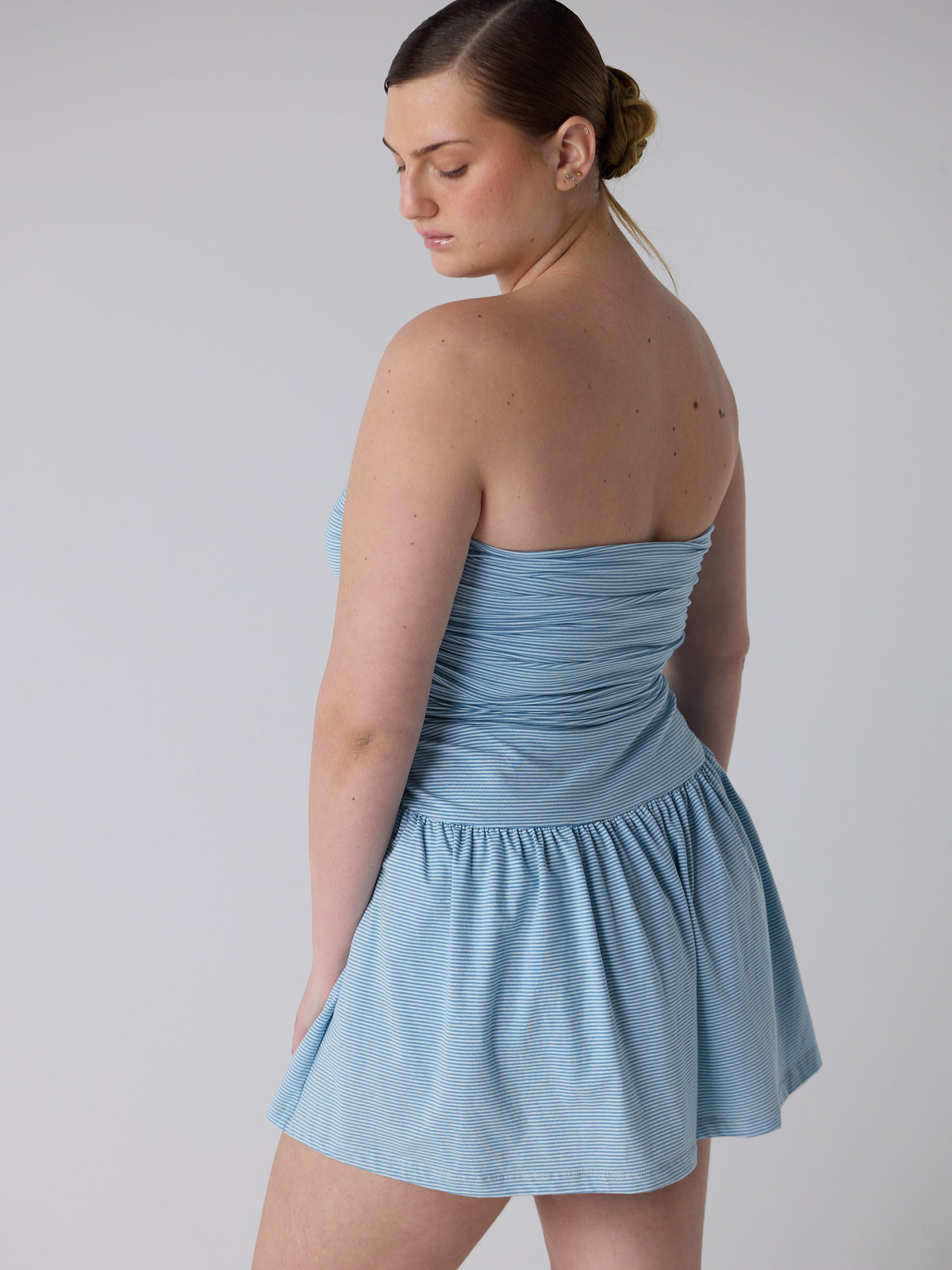 kim wears the twist dress in blue micro stripe, fit 3