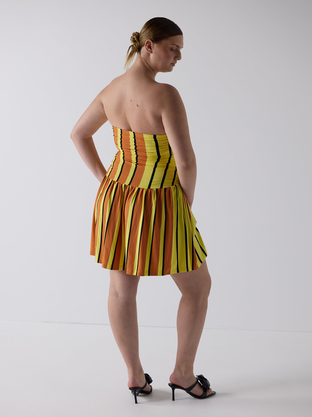 kim wears the twist dress in candy corn, fit 3