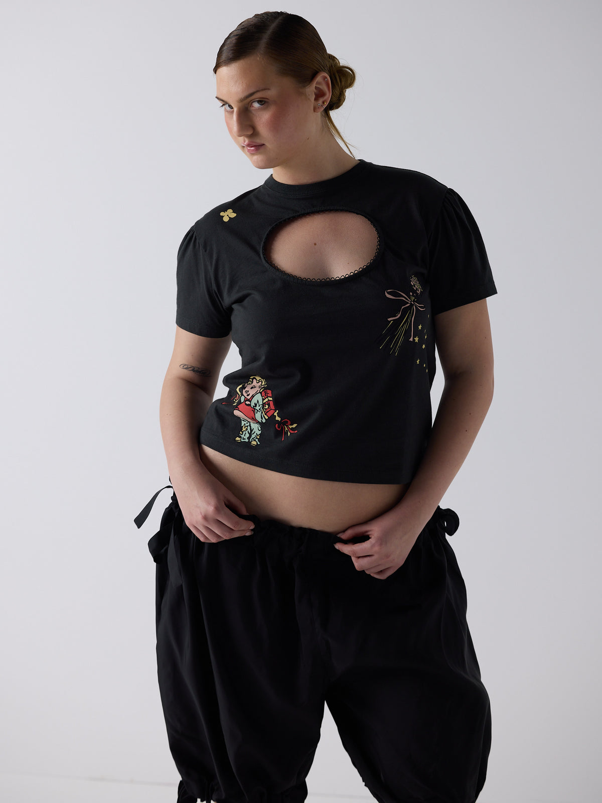kim wears the logo removal baby tee in cutie charcoal, size 2xl