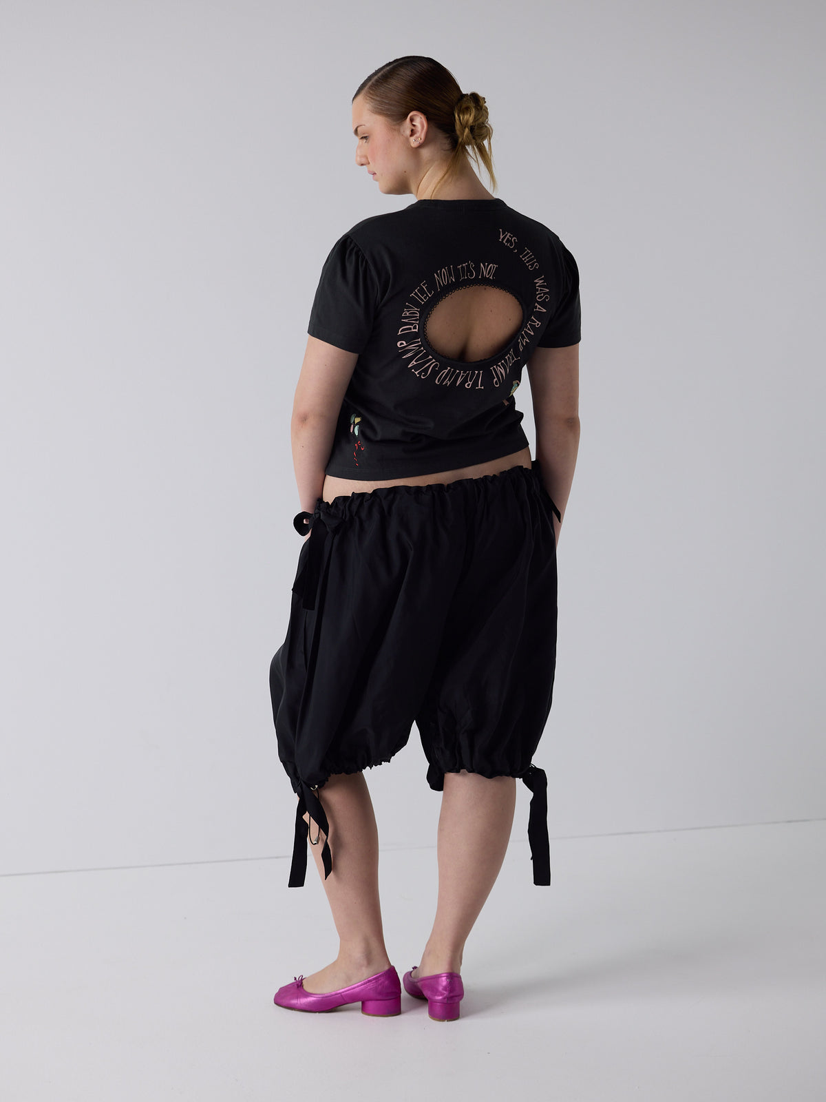 kim wears the logo removal baby tee in cutie charcoal, size 2xl