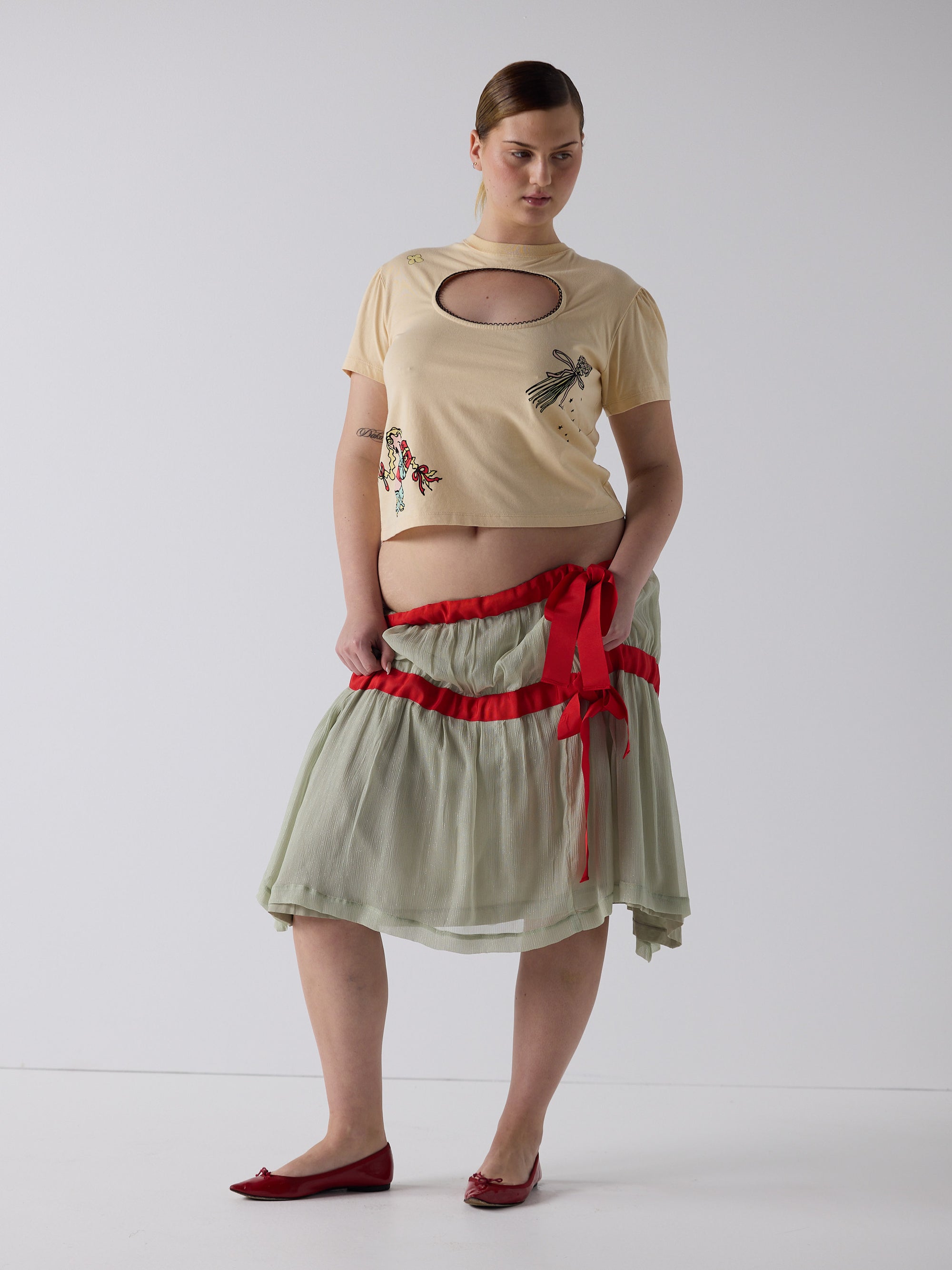 kim wears the logo removal baby tee in cutie creme fraiche, size 2xl