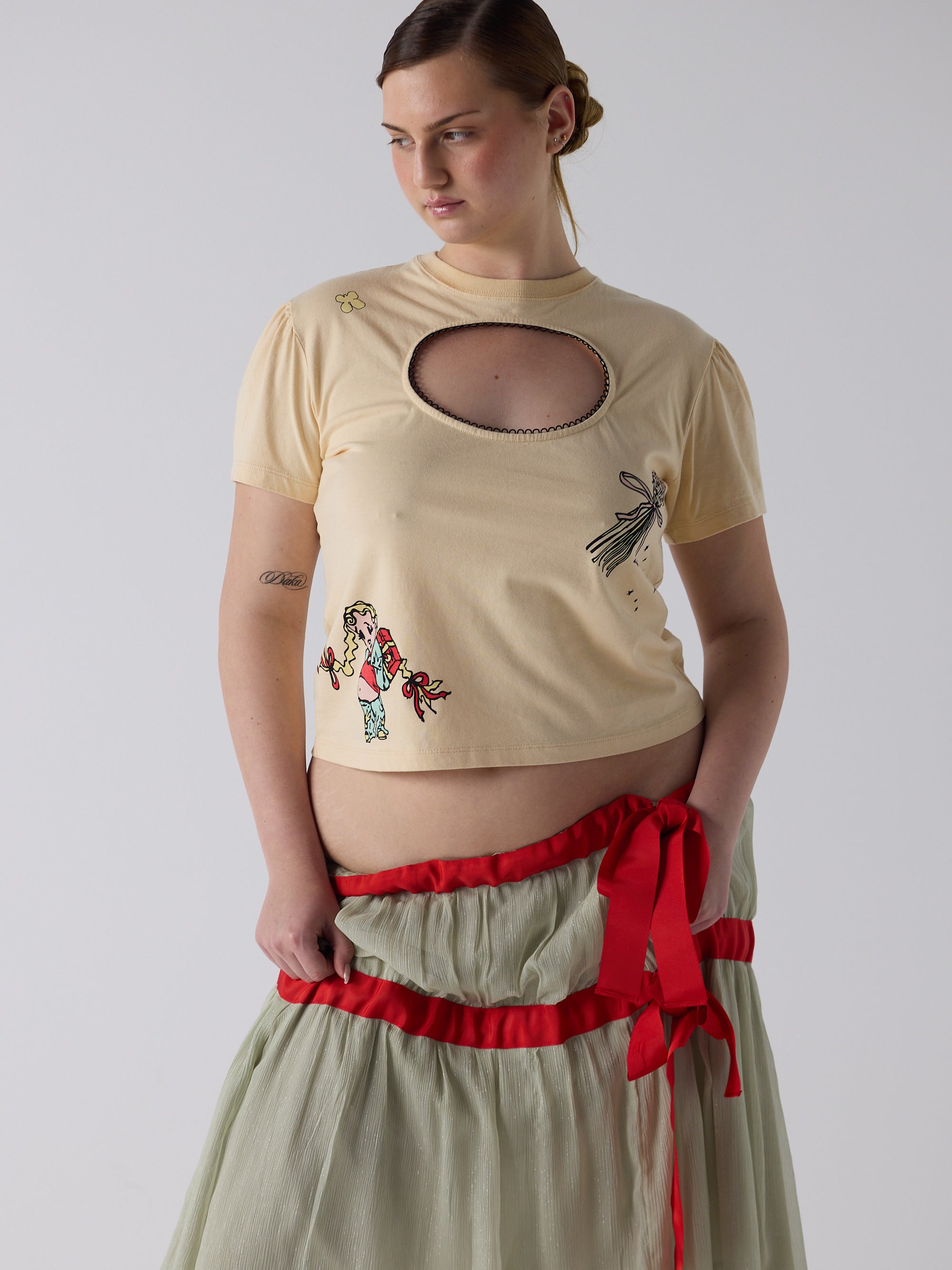 kim wears the logo removal baby tee in cutie creme fraiche, size 2xl