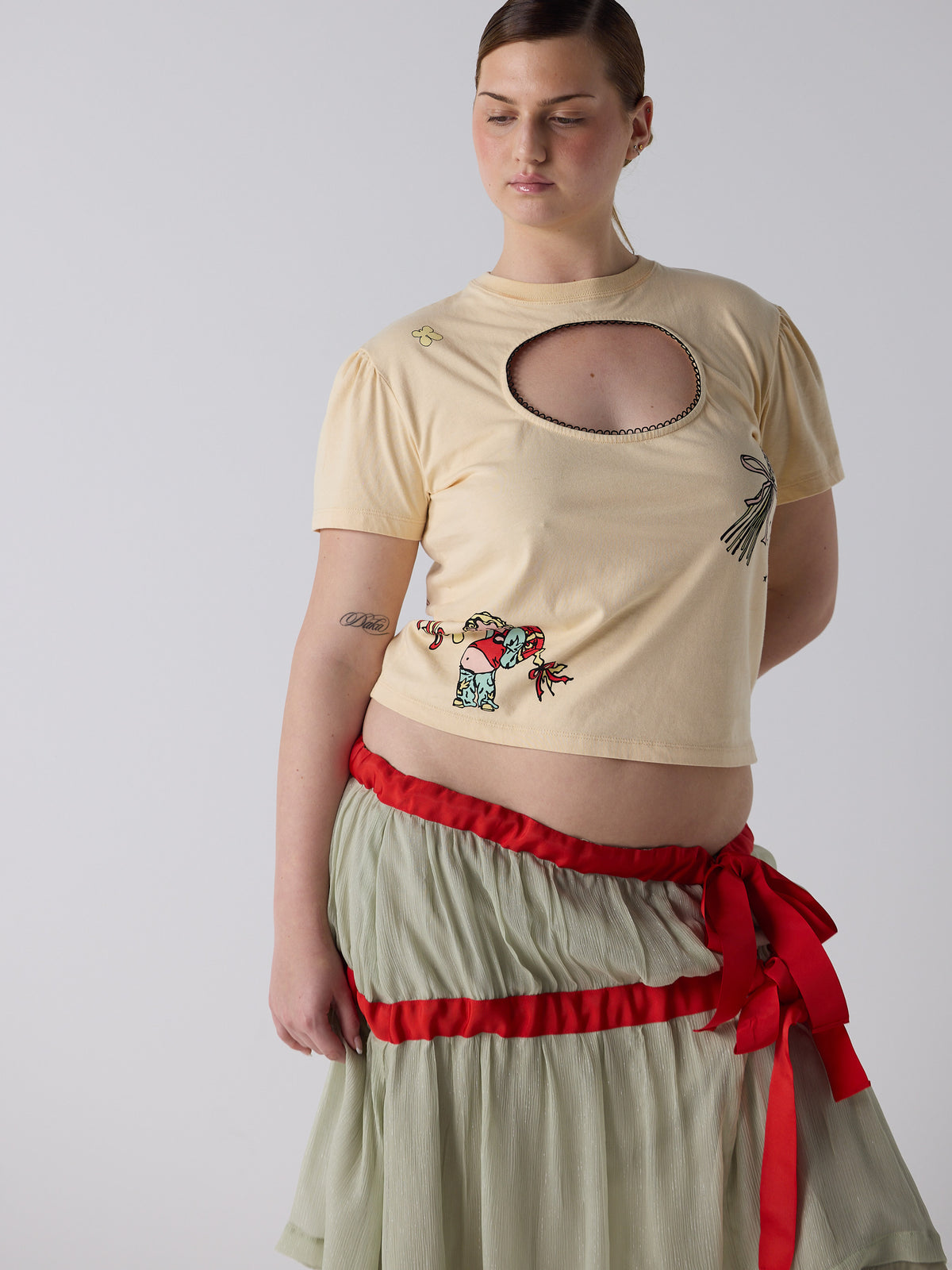 kim wears the logo removal baby tee in cutie creme fraiche, size 2xl