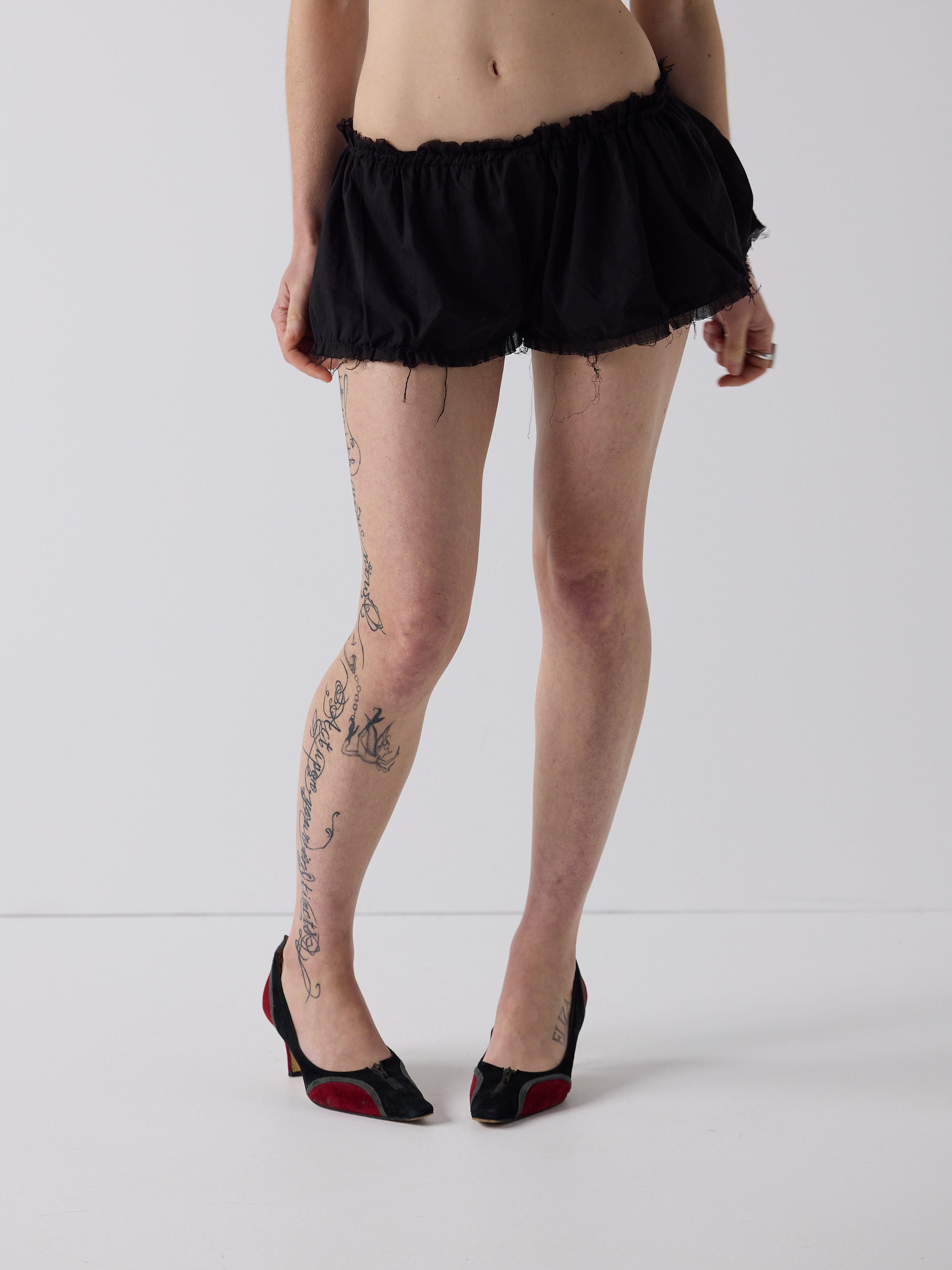 honor wears the niamh galea puff shorts in black cotton voile, a raw edged mini short with a gathered puff silhouette