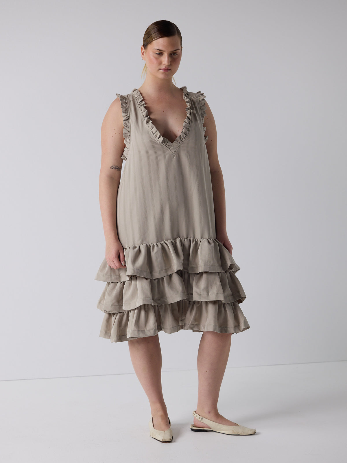 kim wears the tiered drop waist dress in sandstone