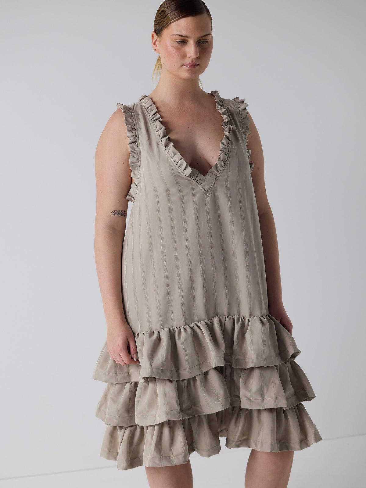 kim wears the tiered drop waist dress in sandstone