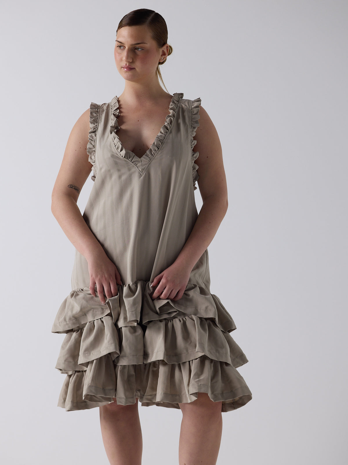 kim wears the tiered drop waist dress in sandstone